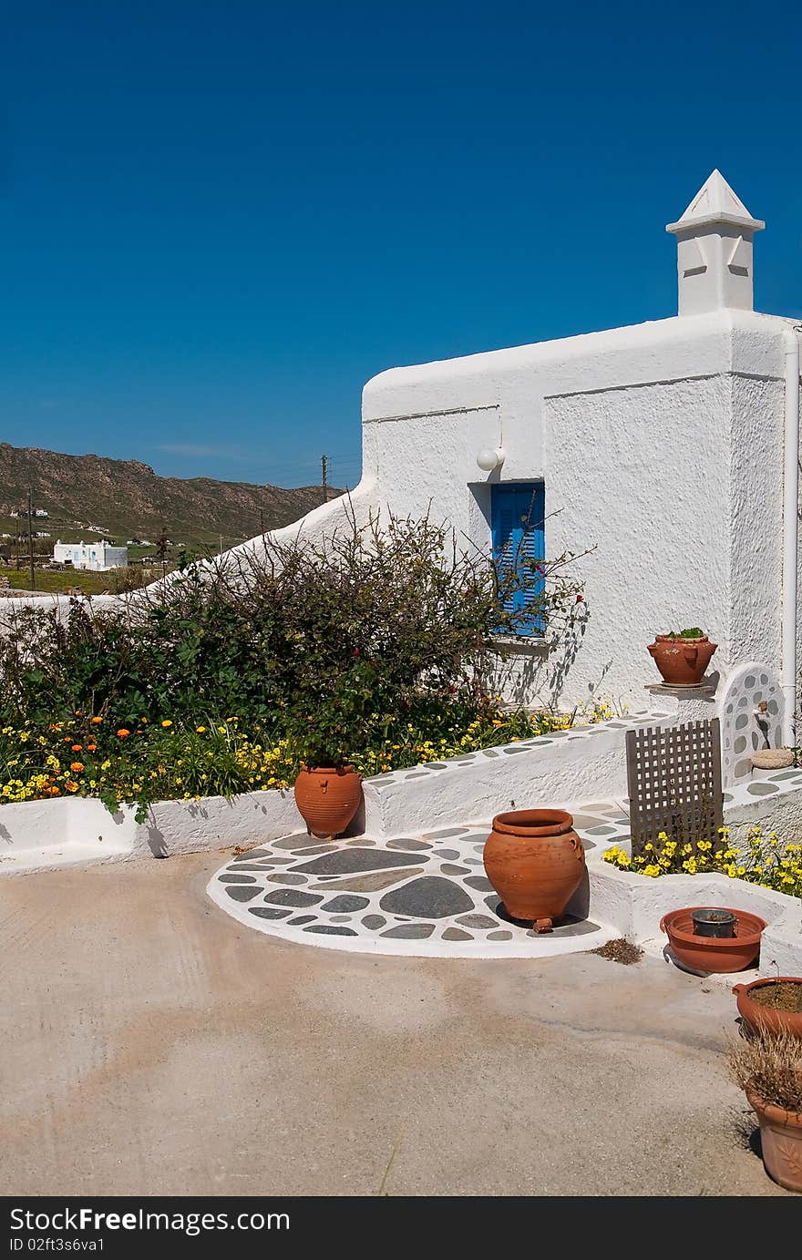 Courtyard Village house with flowers and pots, traditional for Greece. Courtyard Village house with flowers and pots, traditional for Greece.