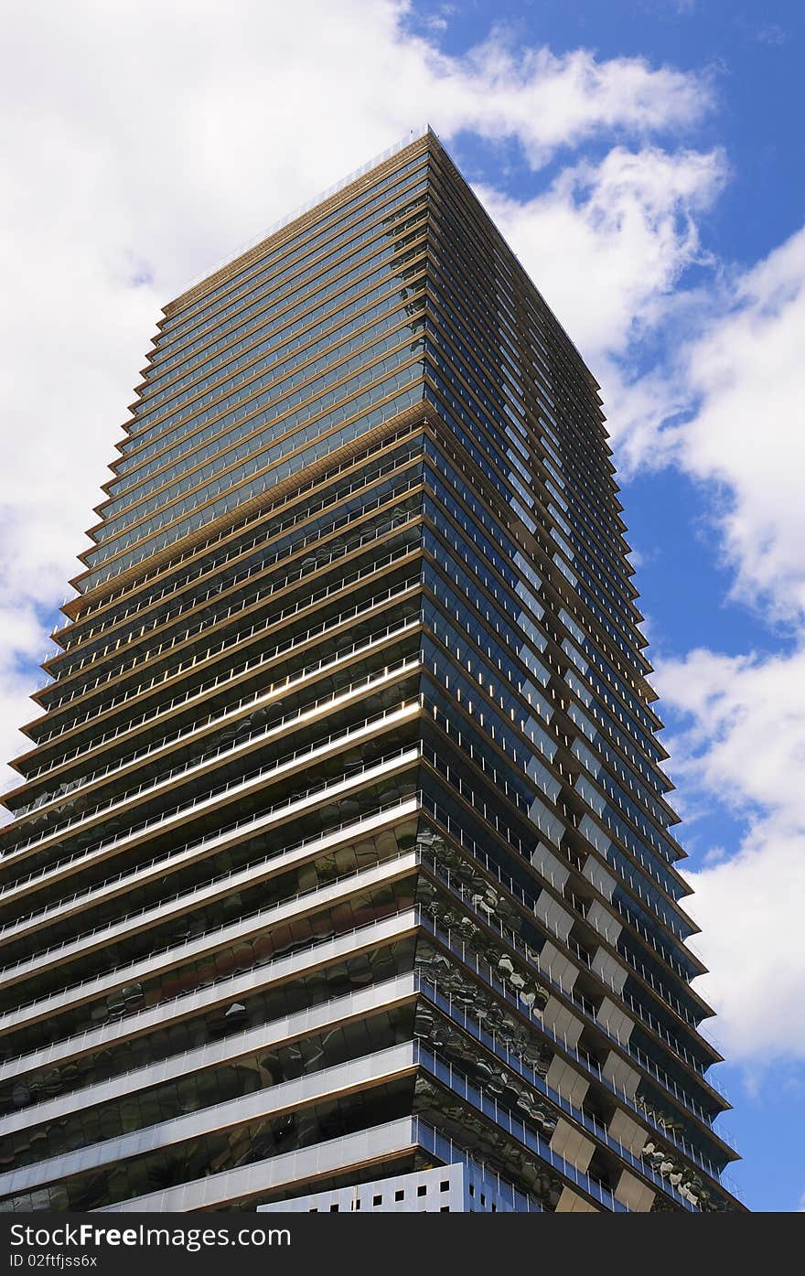 A skyscraper etched against a cloudy sky.