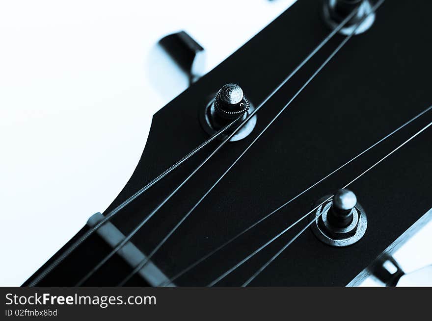 Guitar machine heads and strings against a white background.