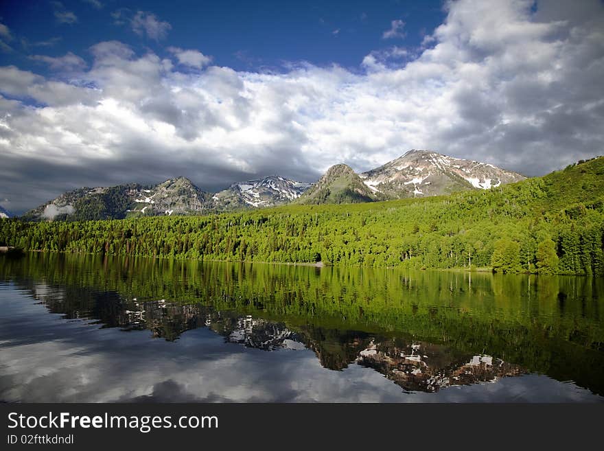 Mountain lake in the Spring with clouds and reflections