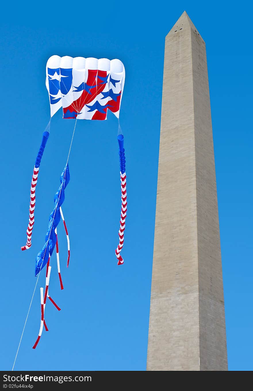 Large patriotic kite captured being flown next to Washington Monument.