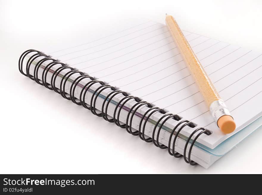 Pencil and notebook on white background