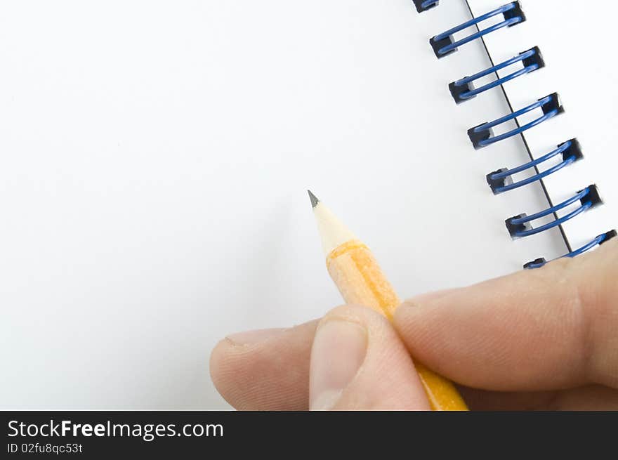 Pencil in hand and notebook on white background