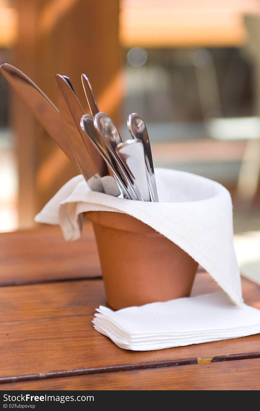 Original table setting knives and forks in a clay pot