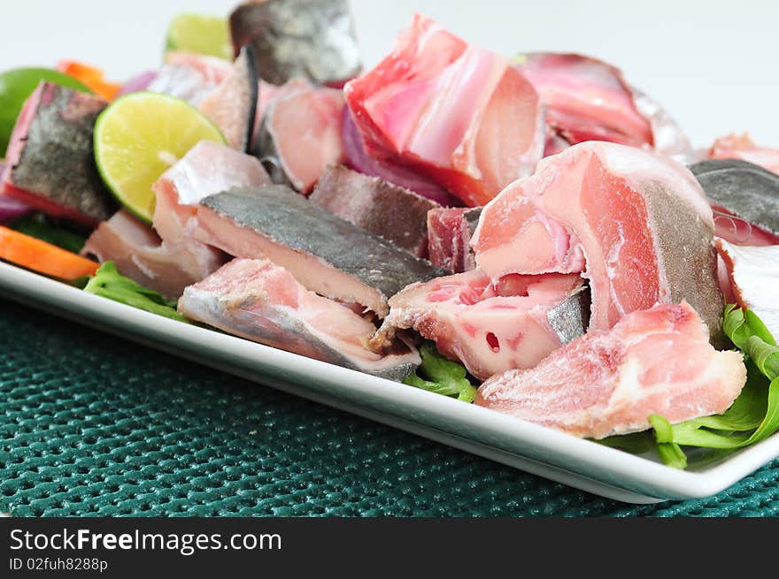 Slices of raw fish with bones and vegetables. Slices of raw fish with bones and vegetables.