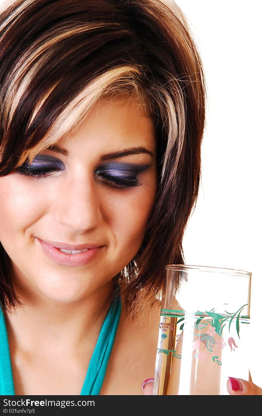 An pretty smiling girl with a glass full of water, in a closeup shot, standing in the studio and looking down, for white background. An pretty smiling girl with a glass full of water, in a closeup shot, standing in the studio and looking down, for white background.