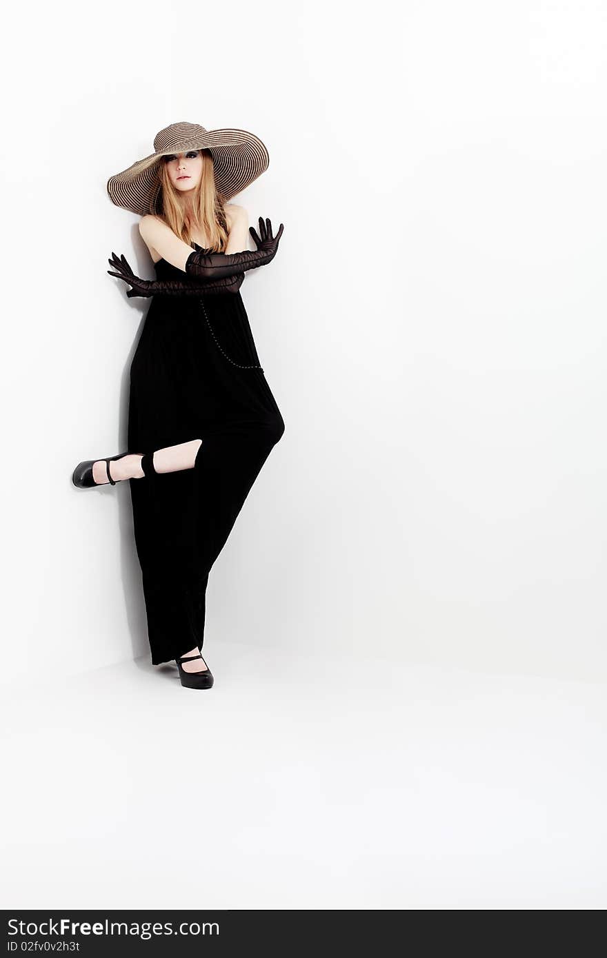 Portrait of a beautiful girl in elegant black dress and a  hat. Portrait of a beautiful girl in elegant black dress and a  hat.