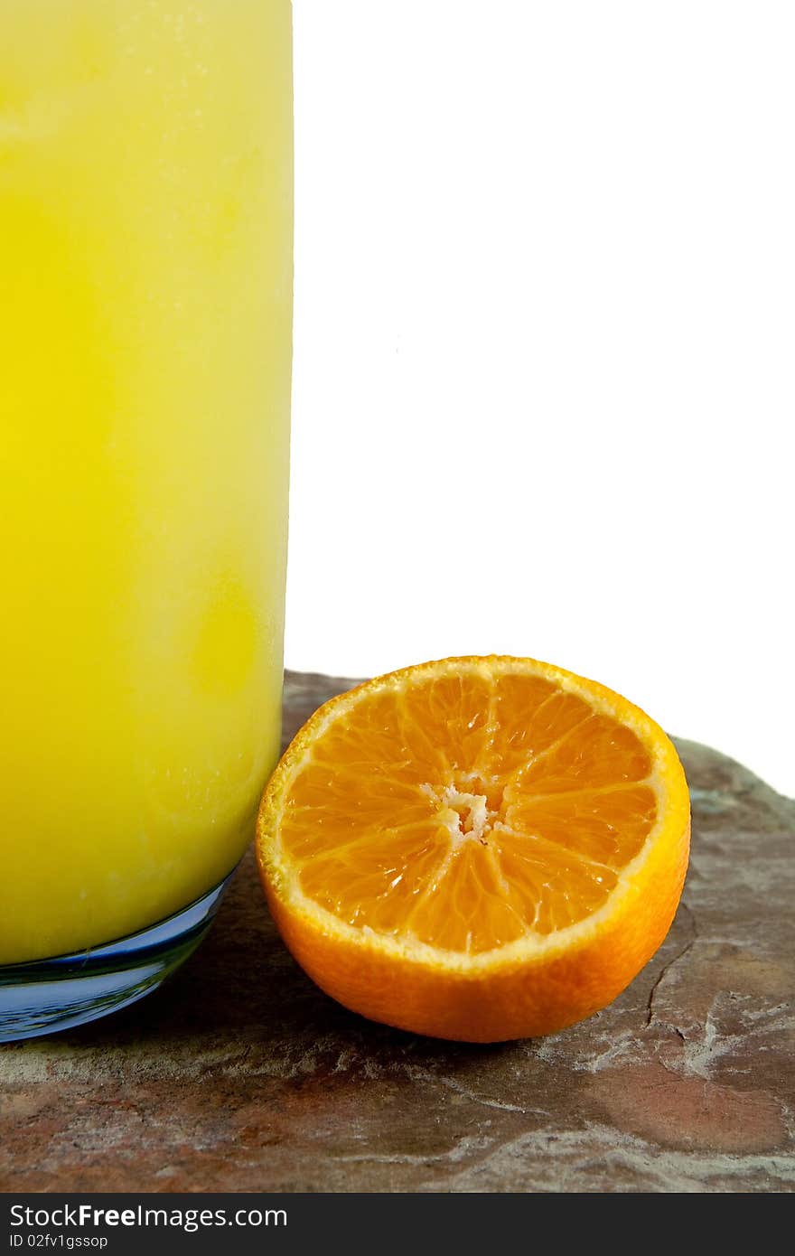 One half orange and glass of orange juice on stone table isolated on white background. One half orange and glass of orange juice on stone table isolated on white background.