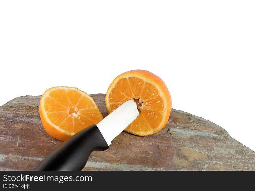 Orange cut in half with knife in foreground. Orange cut in half with knife in foreground..