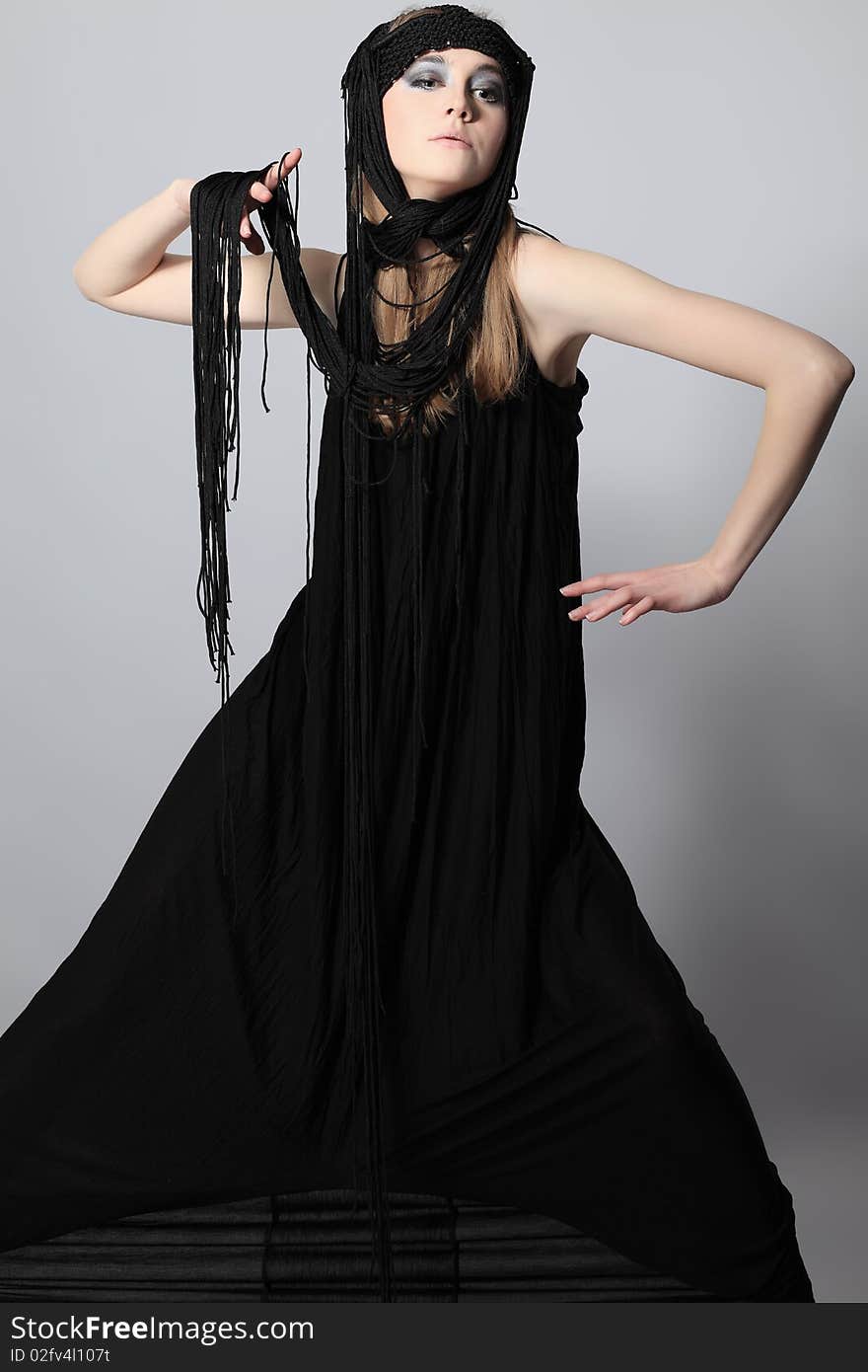 Portrait of a beautiful girl in elegant black dress. Shot in a studio. Portrait of a beautiful girl in elegant black dress. Shot in a studio.