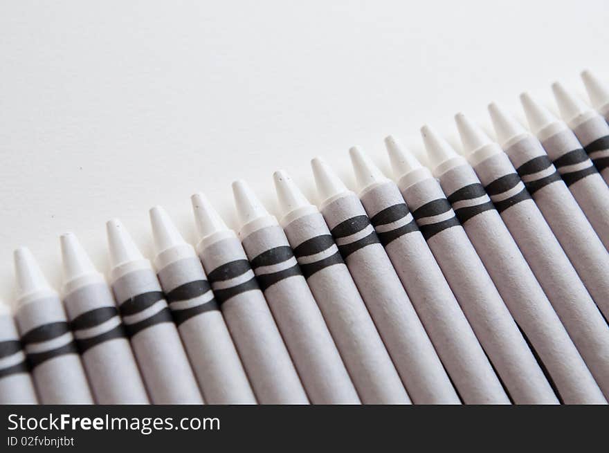 A row of all white crayons against a white background