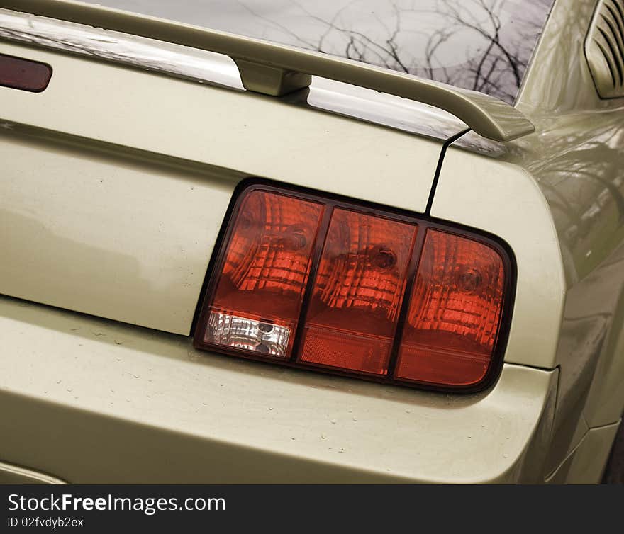 Modern muscle car shot from the rear passenger side showing taillight and spoiler. Modern muscle car shot from the rear passenger side showing taillight and spoiler