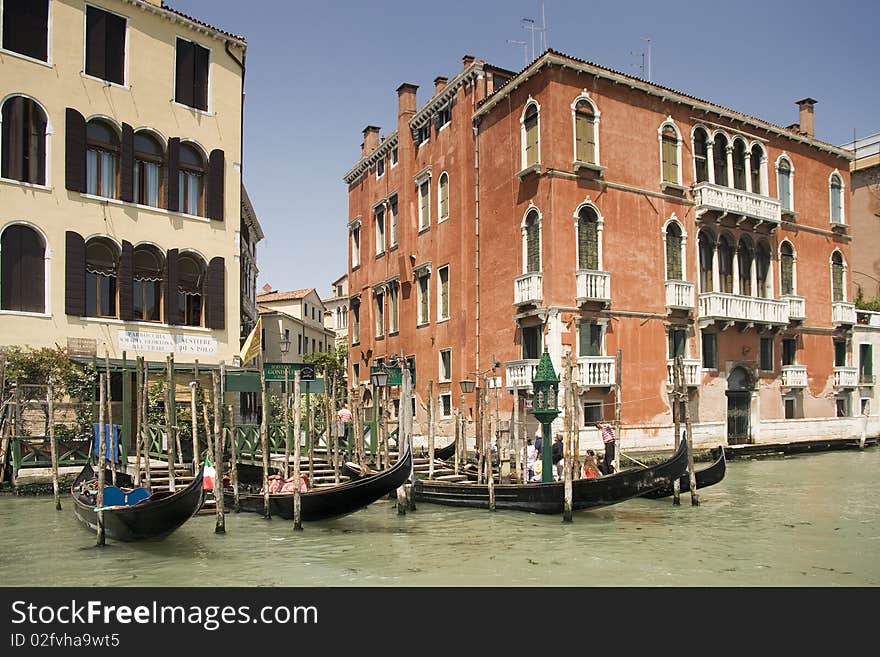 Gondolas at Grand Canal among old and multicolored houses in Venice, Italy. Gondolas at Grand Canal among old and multicolored houses in Venice, Italy