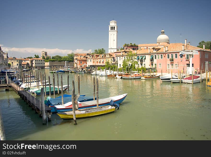 Boats at venetian canal among old and multicolored houses in Venice, Italy. Boats at venetian canal among old and multicolored houses in Venice, Italy