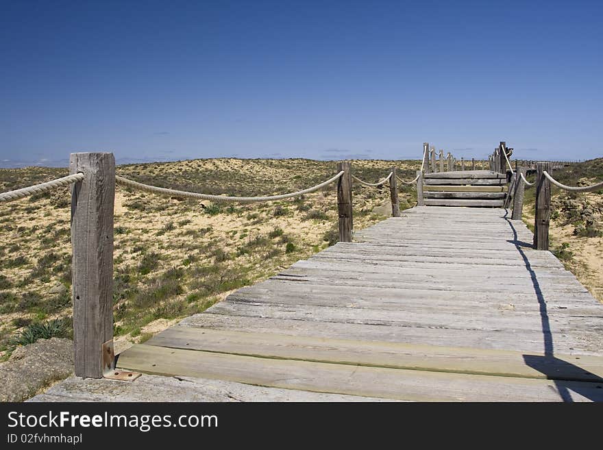 Wood path going to a wild and empty beach. Wood path going to a wild and empty beach