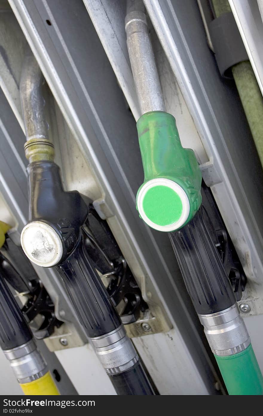 Gas nozzles at the gas station. Shallow depth of field with focus on just one nozzle