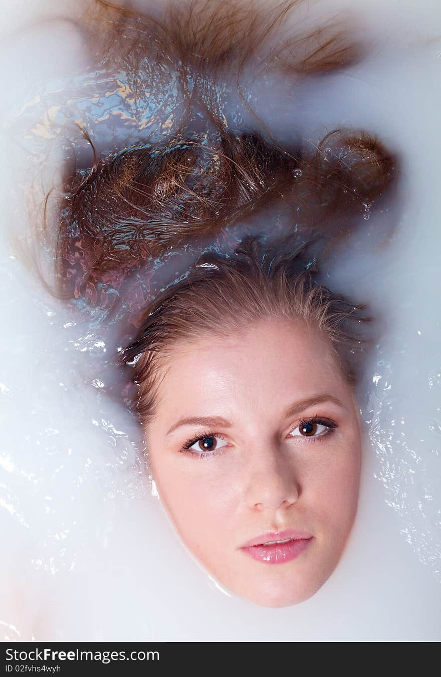 Beauty woman in bathroom with water with milk