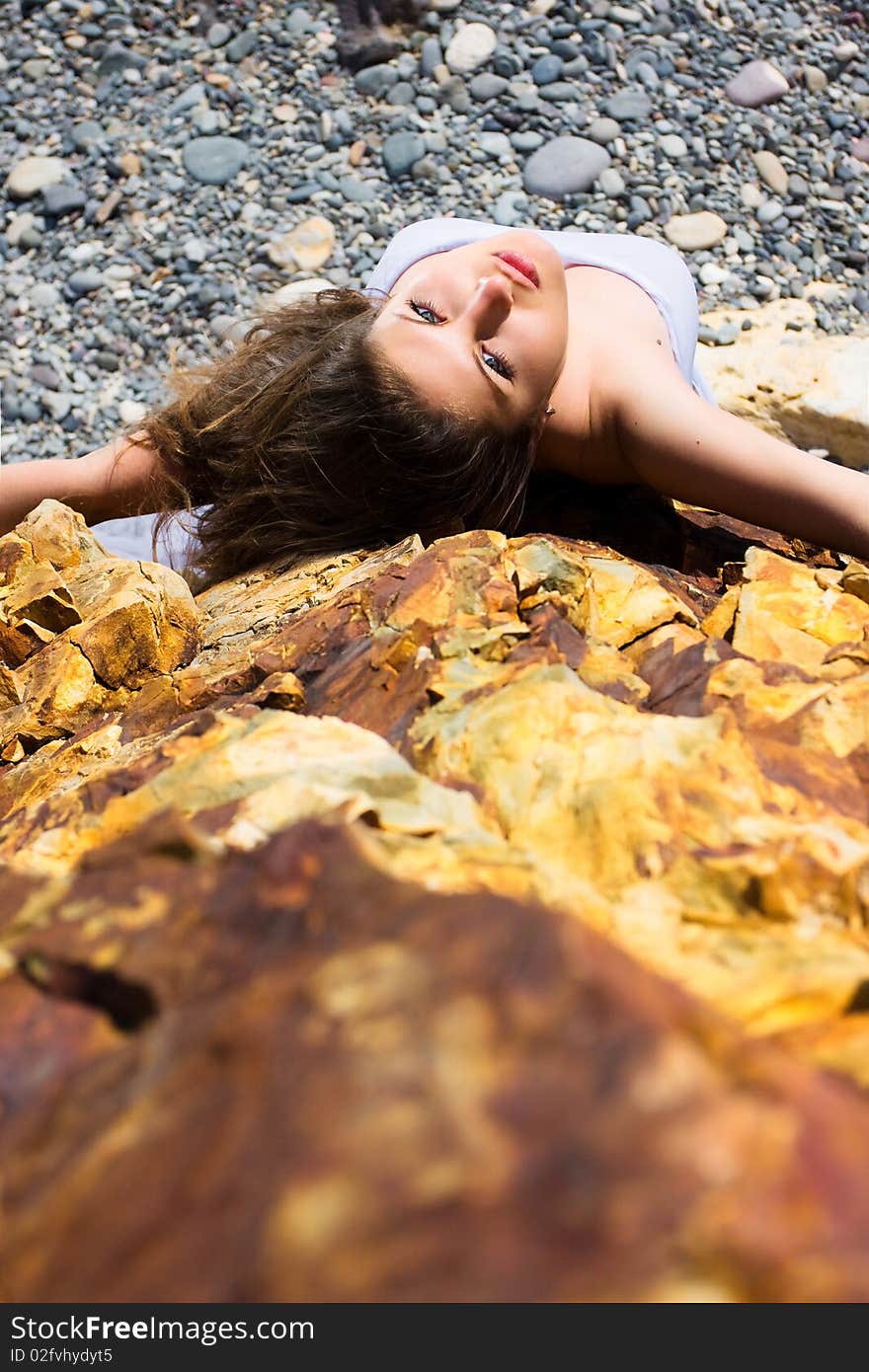 Woman in white dress from material and rocks