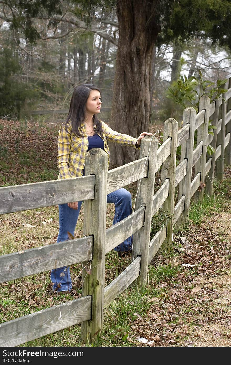 Young woman propped on old wooden pasture fence. Young woman propped on old wooden pasture fence