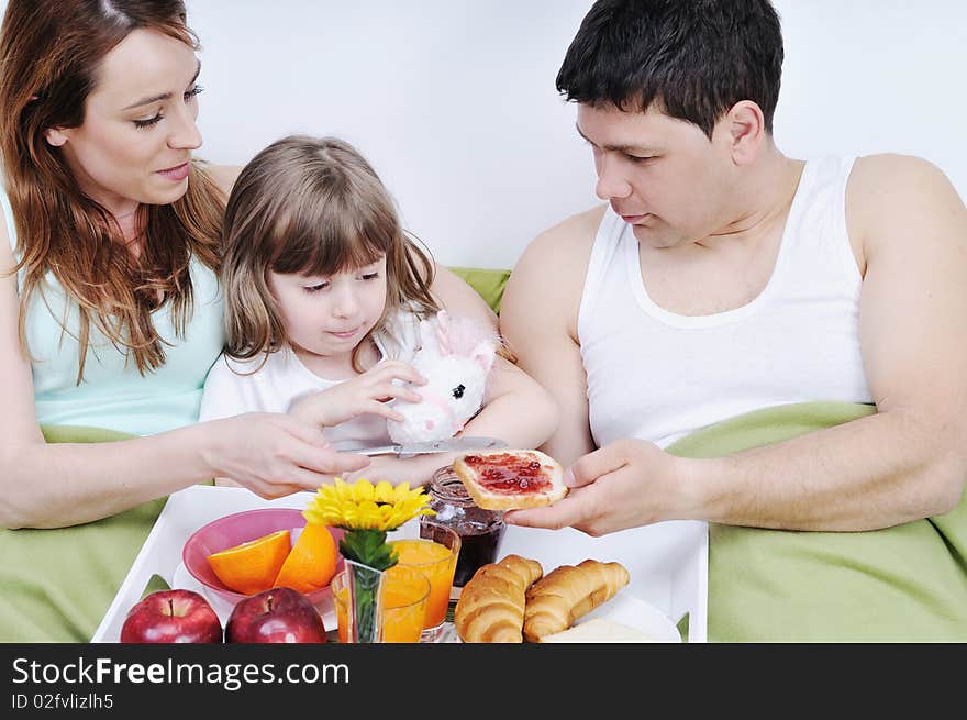 Happy Young Family Eat Breakfast In Bed