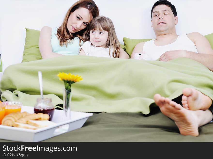 Happy Young Family Eat Breakfast In Bed