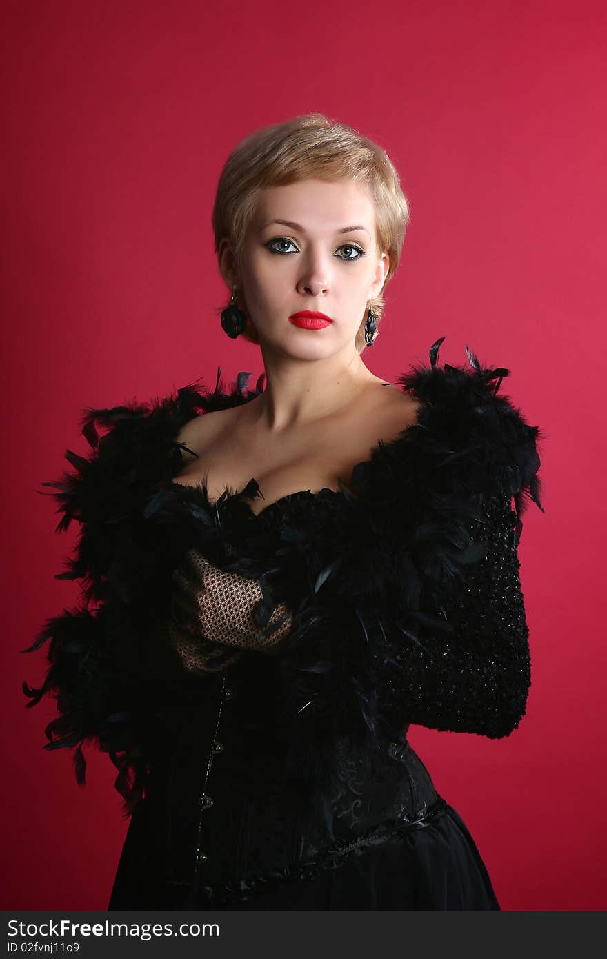 The blonde in a black boa on a red background