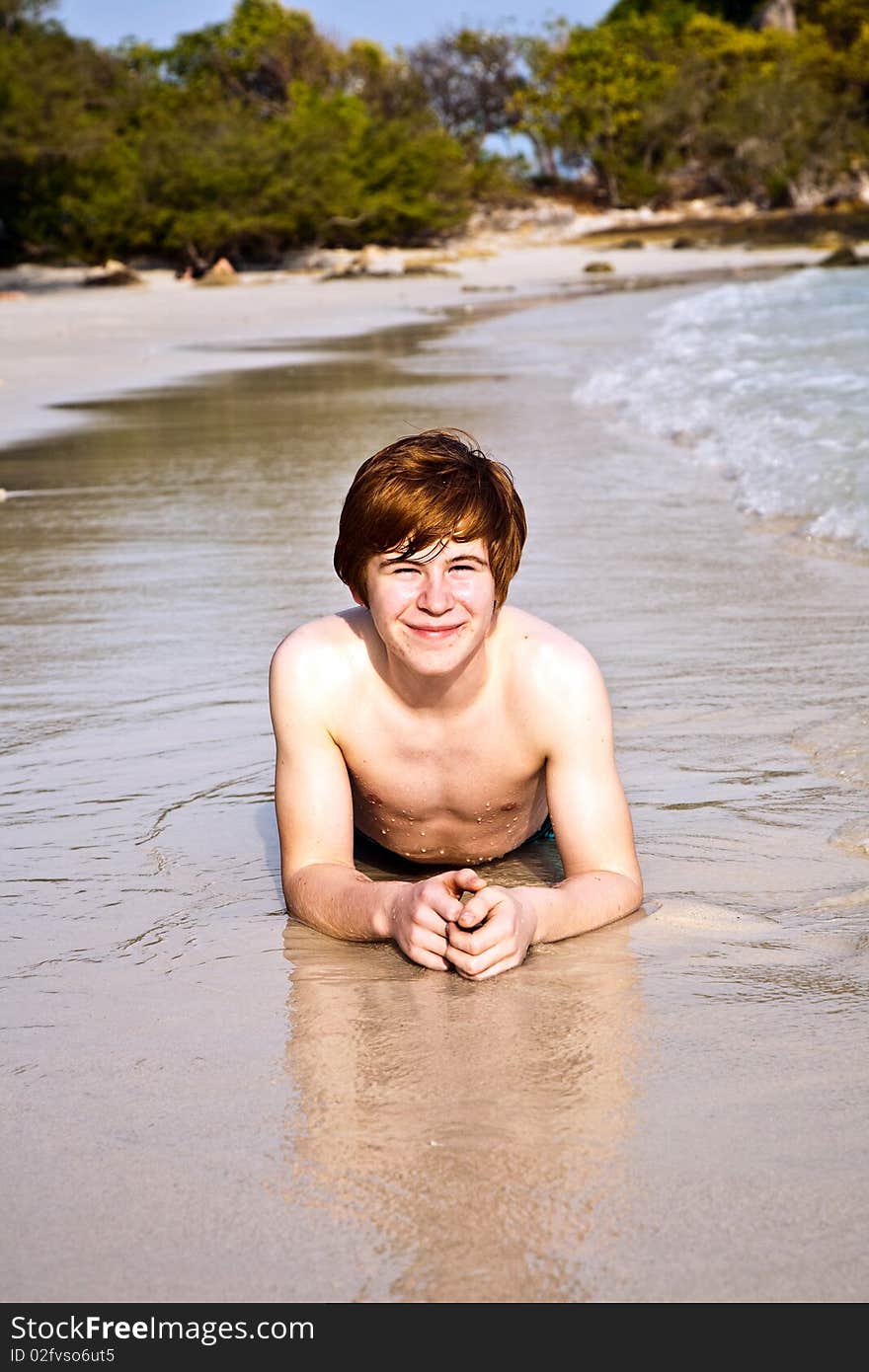 Happy boy with red hair is enjoying the beach