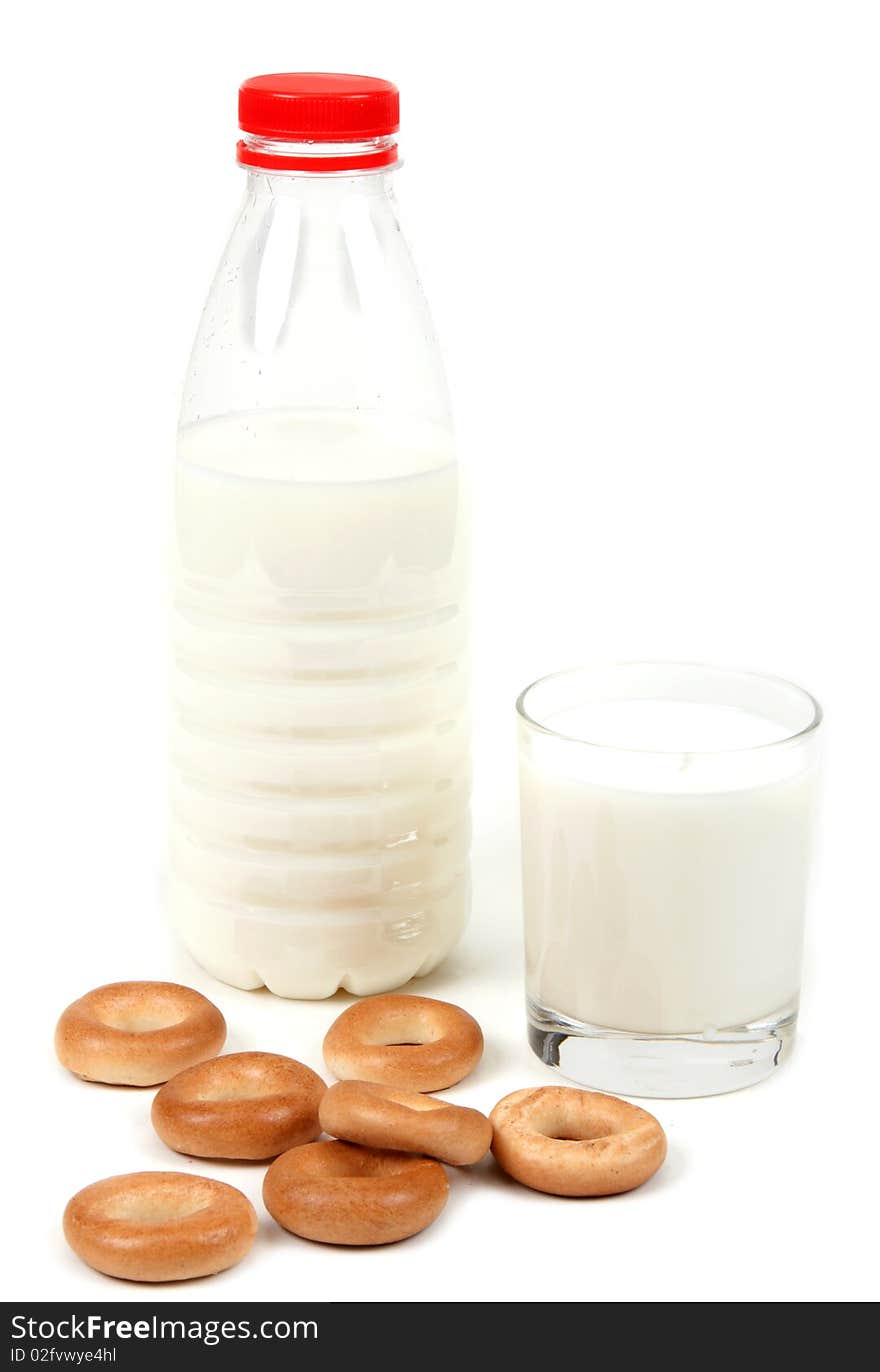 Bottle and glass milk with bagel on white background