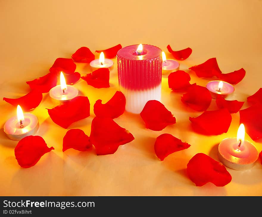 Spa lit candles among damask rose petals. Spa lit candles among damask rose petals