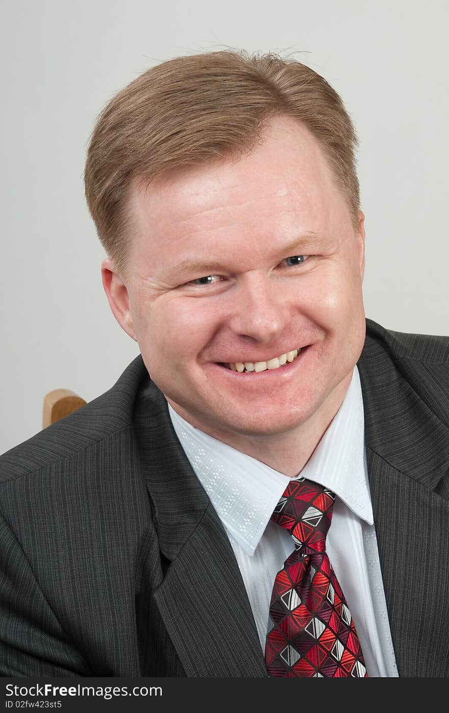 The man in a grey suit and a red tie in good mood. It the successful businessman. The man in a grey suit and a red tie in good mood. It the successful businessman.