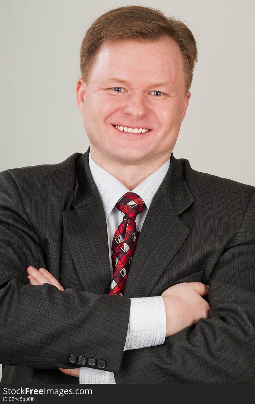 The man in a grey suit and a red tie in good mood. It the successful businessman. The man in a grey suit and a red tie in good mood. It the successful businessman.