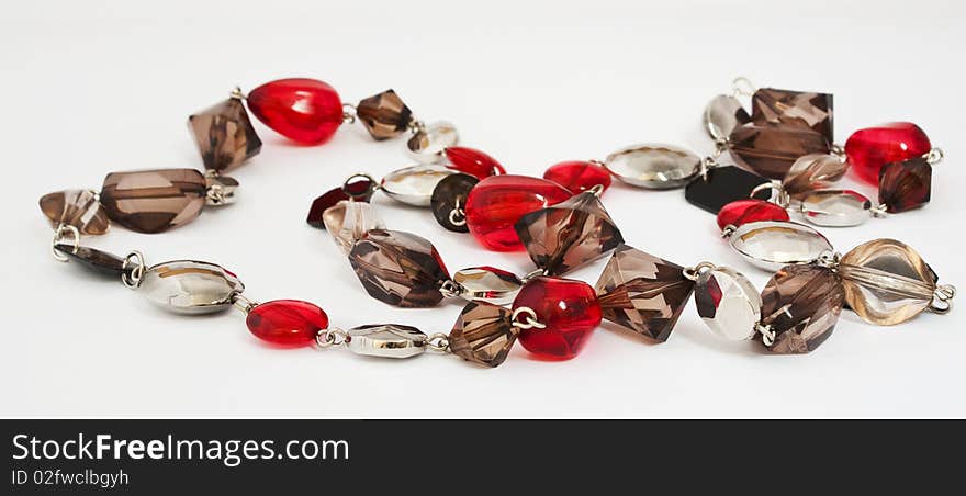 Beads of red and beige glass on a white background. Beads of red and beige glass on a white background