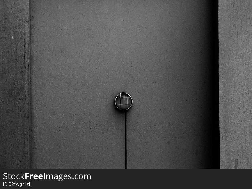 A solitary lamp on a gray wall. A solitary lamp on a gray wall.