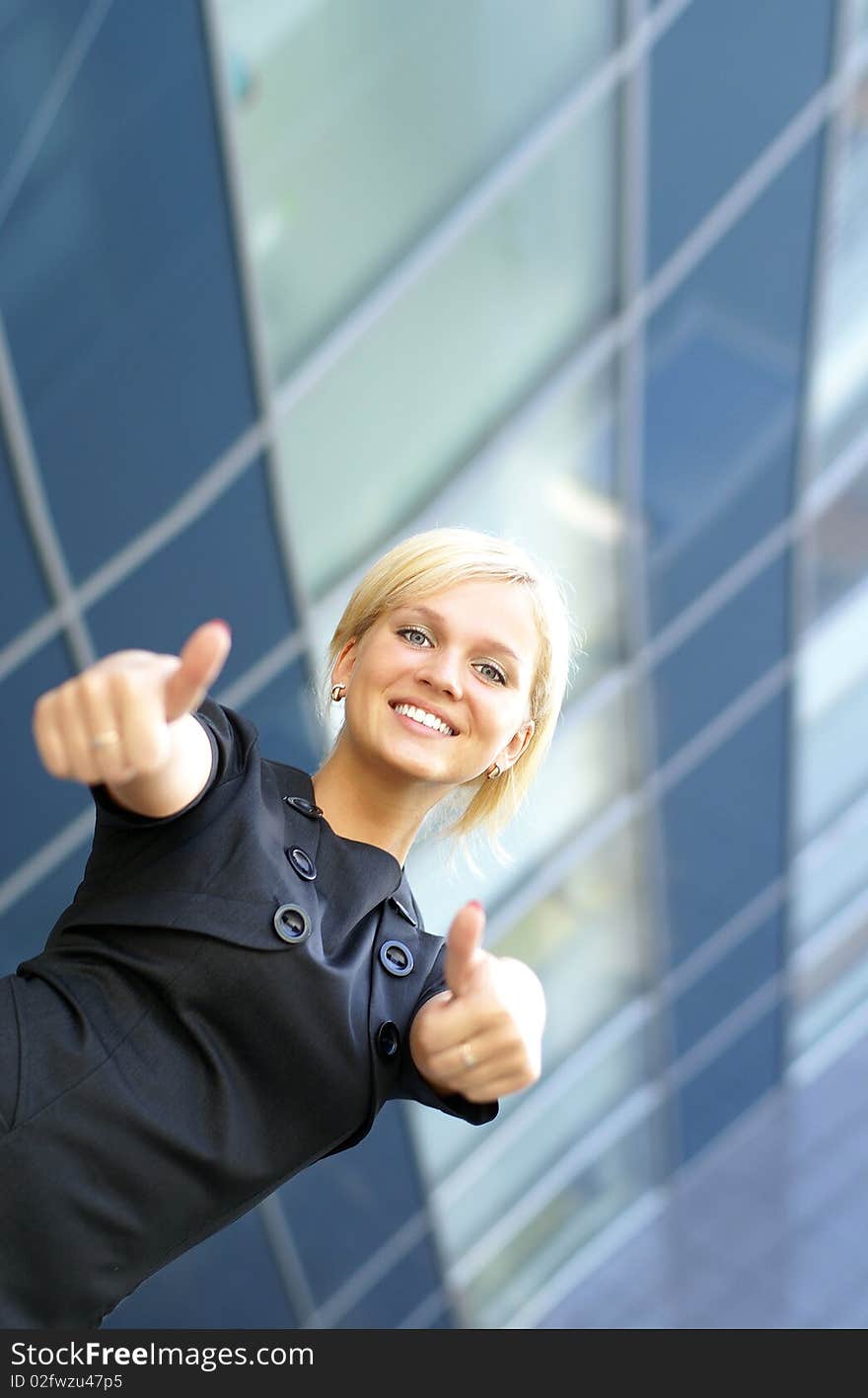 Businesswoman successfully holds thumbs up. Image taken on a modern abstract background. Businesswoman successfully holds thumbs up. Image taken on a modern abstract background.