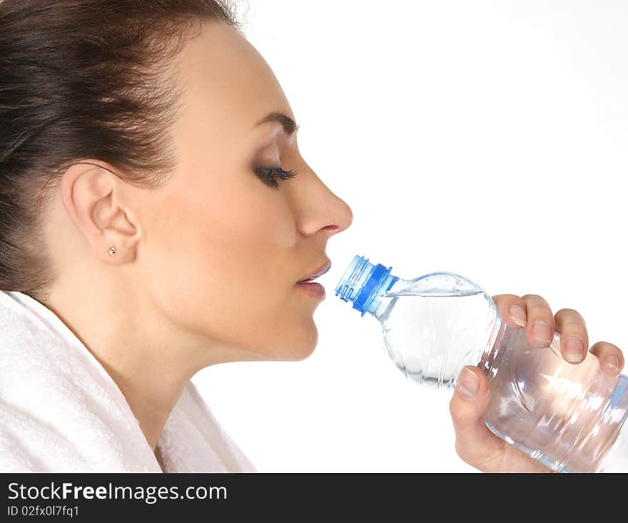 Young and attractive female sportsman drinking water after training. Image isolated on white background.