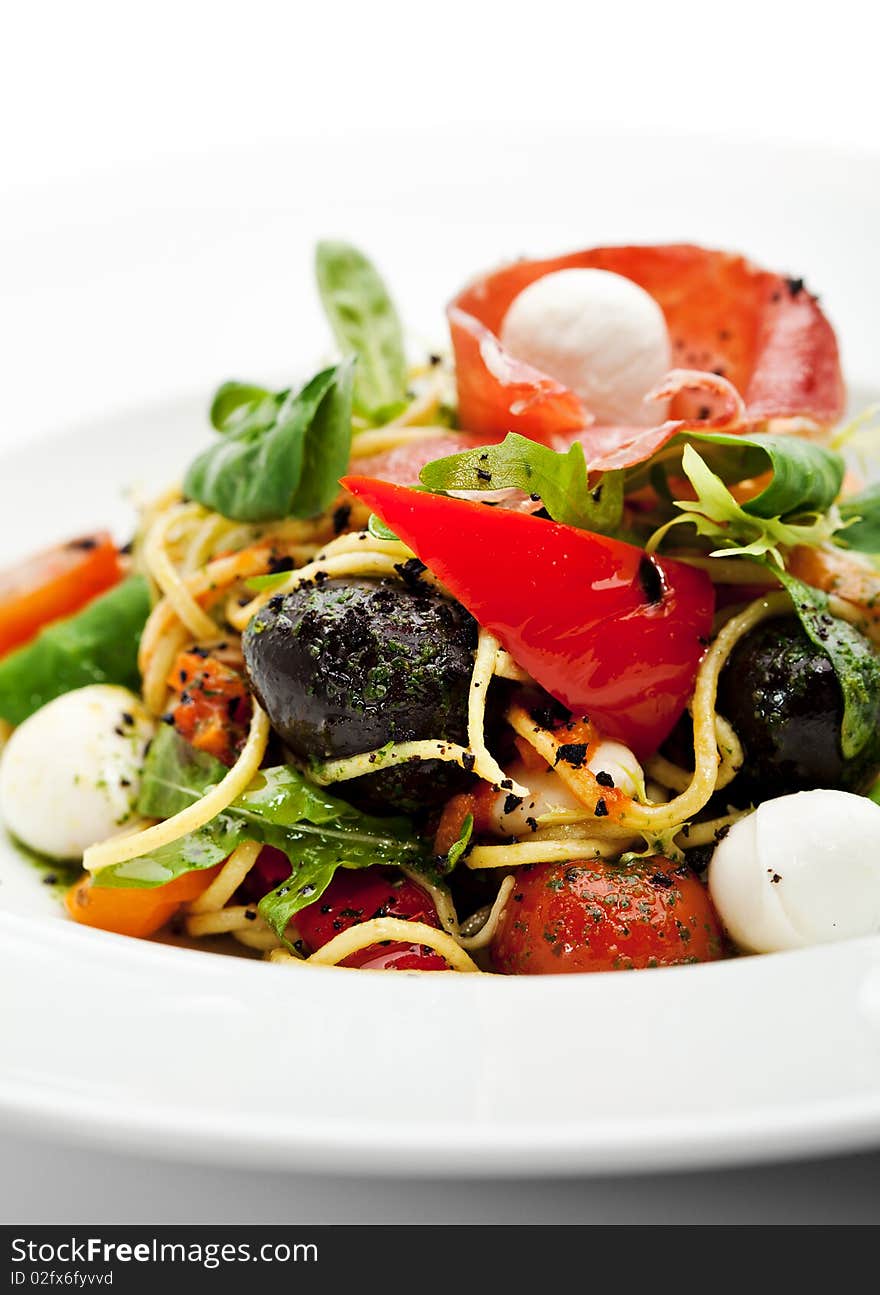 Spaghetti with Vegetables, Ham, Black Olives, Rucola and Pesto Sauce