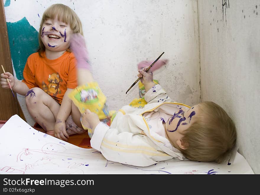 Two dirty children sketching themselves with a paint