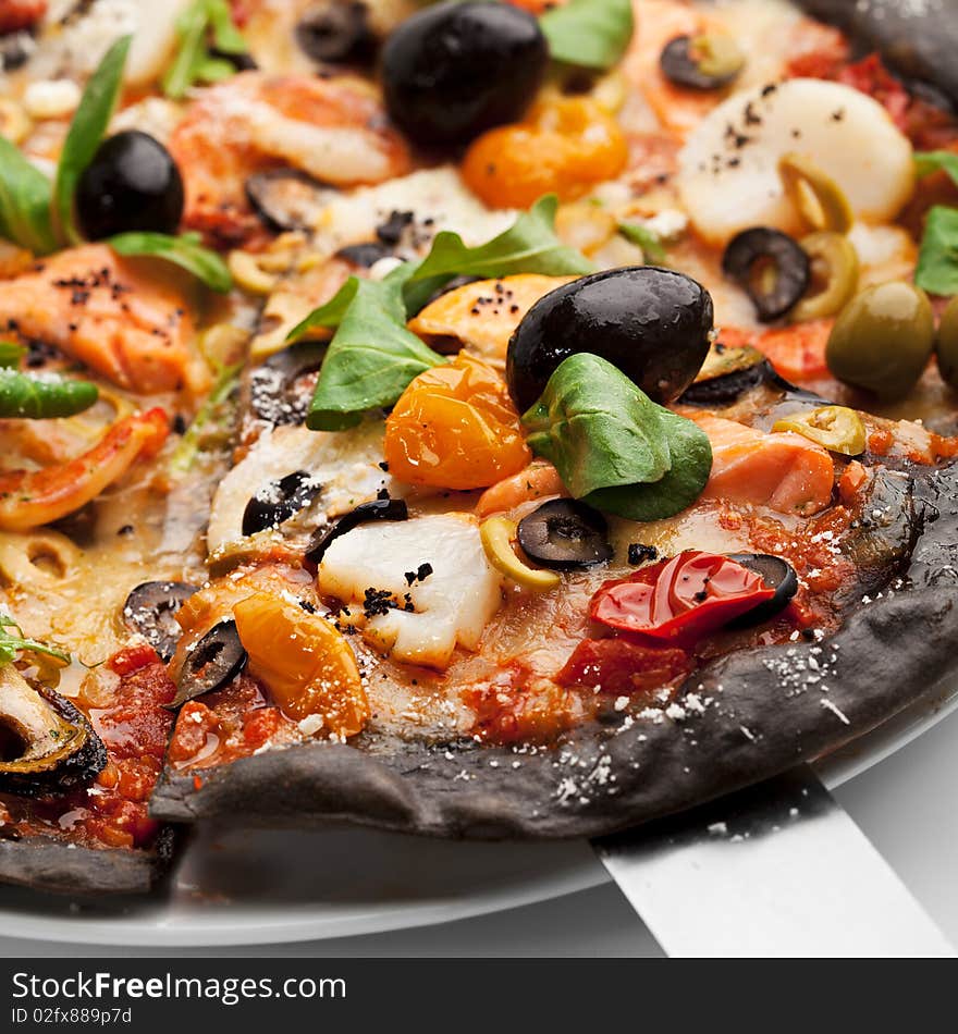 Black Ink Dough Pizza with Seafood, Black and Green Olives, Dried Tomato and Salad Leaves. Black Ink Dough Pizza with Seafood, Black and Green Olives, Dried Tomato and Salad Leaves