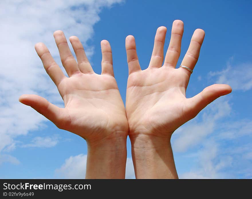 A hands begging alms on a sky background