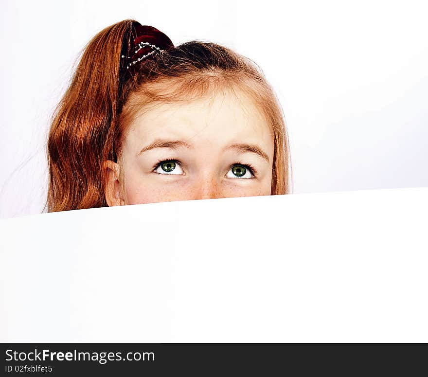 Redhead girl peeping out of paper. Redhead girl peeping out of paper