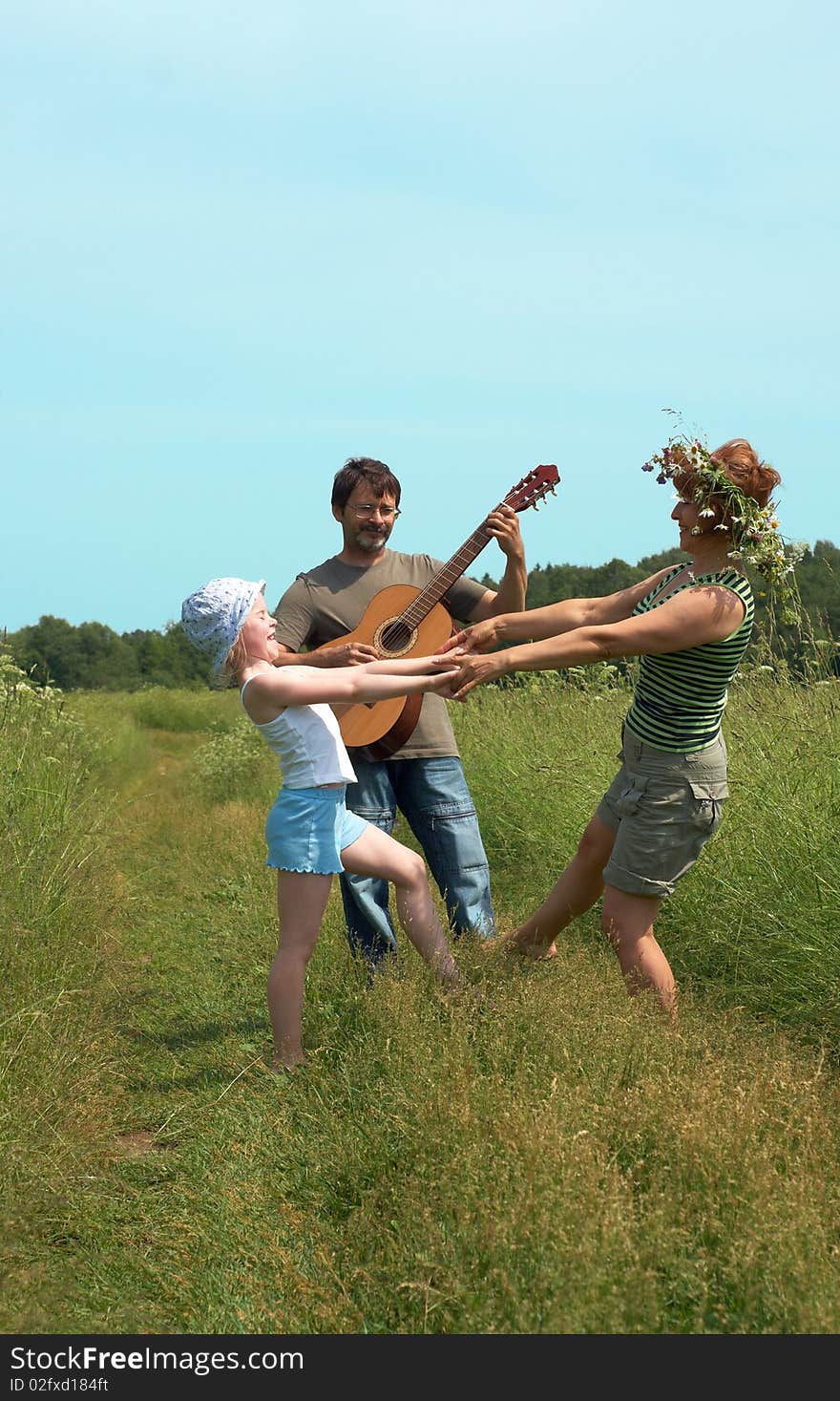 Parents with the daughter play on a meadow. Parents with the daughter play on a meadow