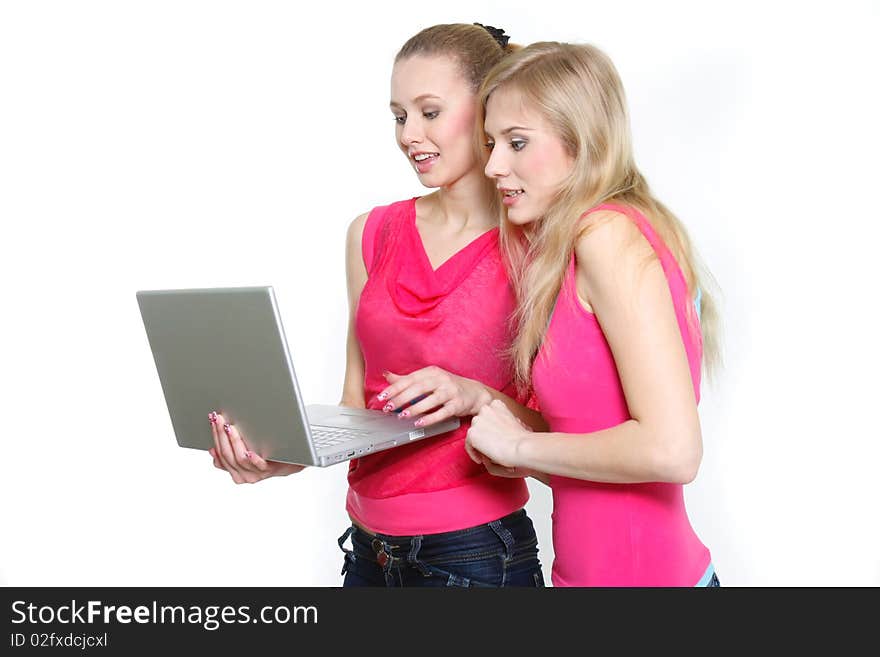 Two young attractive girls with laptop over white