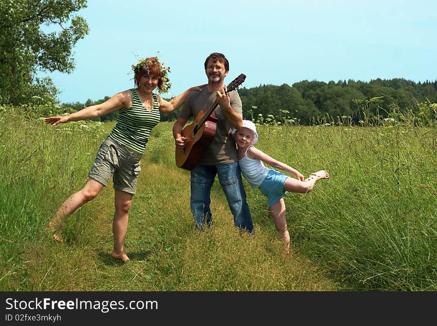 Parents with the daughter play on a meadow. Parents with the daughter play on a meadow