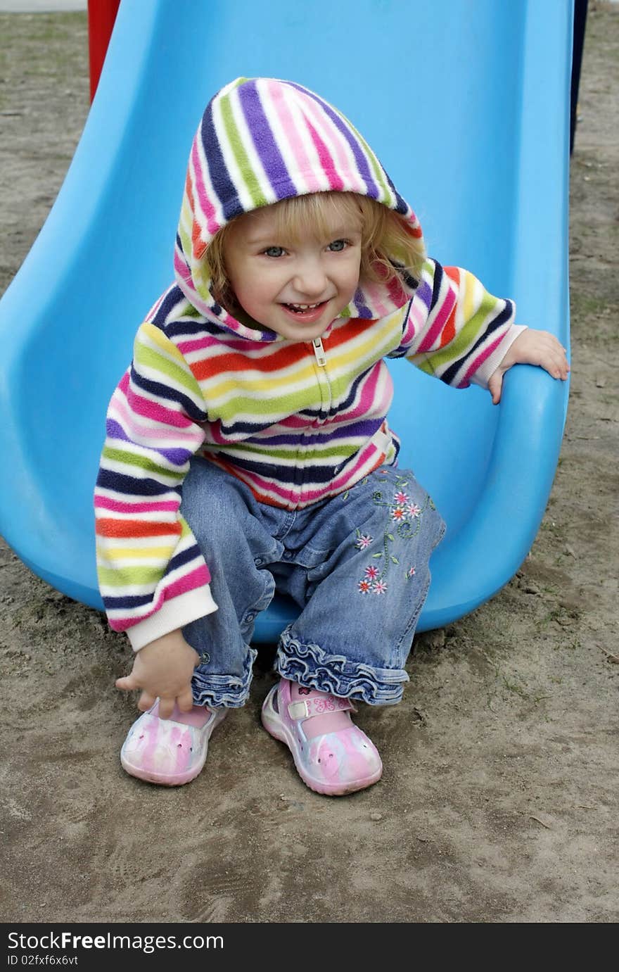 A child in a striped blouse drives off the hill. A child in a striped blouse drives off the hill