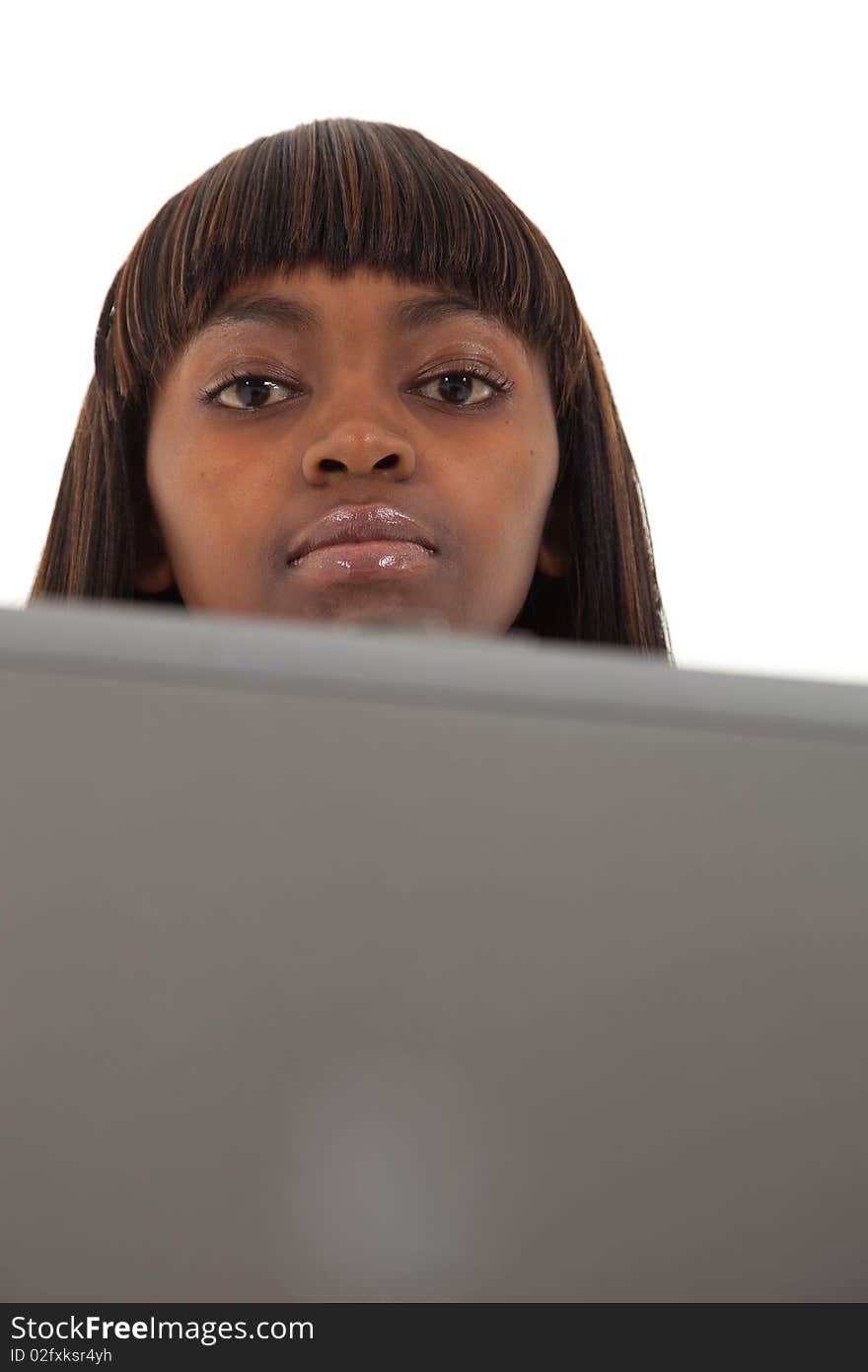 Young black female hiding behind her laptop. Young black female hiding behind her laptop