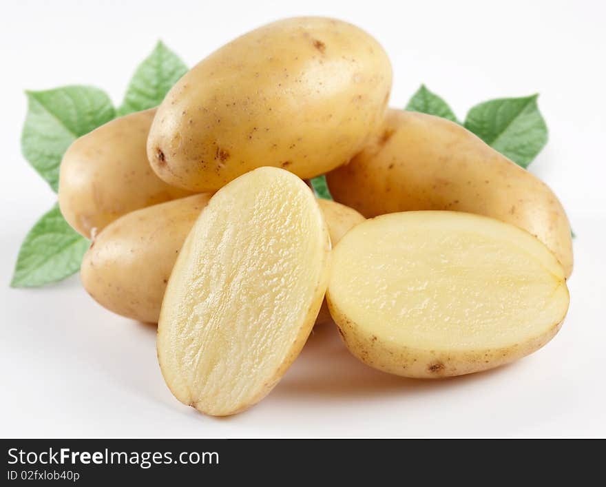 Yellow potatoes with leaves on a white background