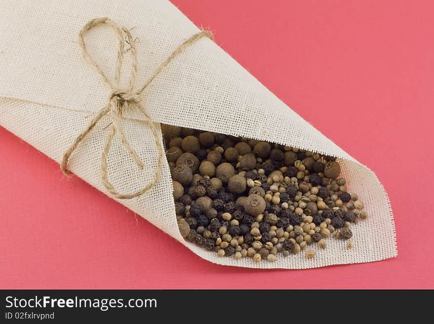 Sack with spices on a red background