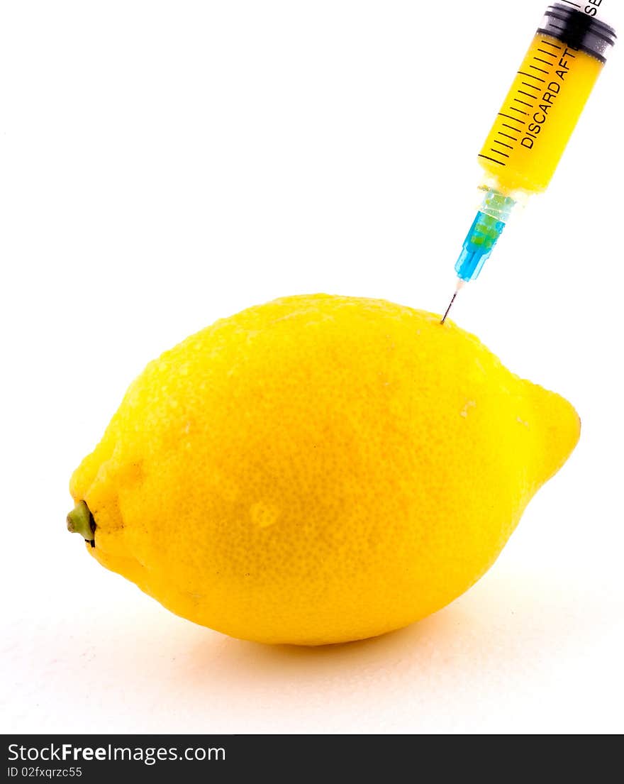 Lemon With Syringe Injecting Color on Isolated White Background