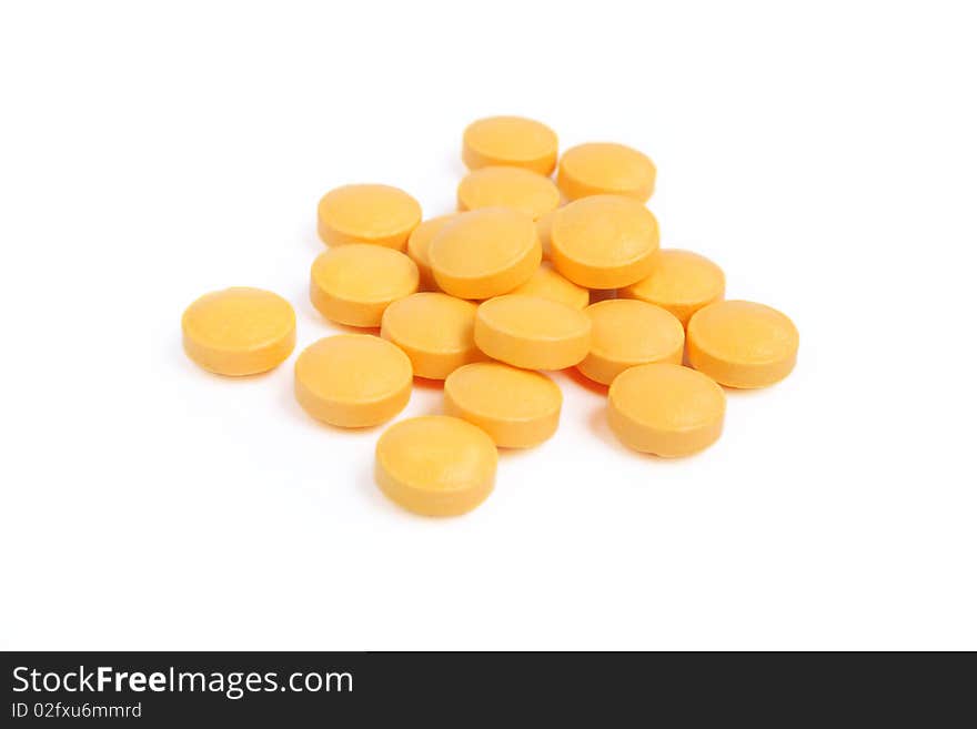 Pile of orange pills isolated on white background