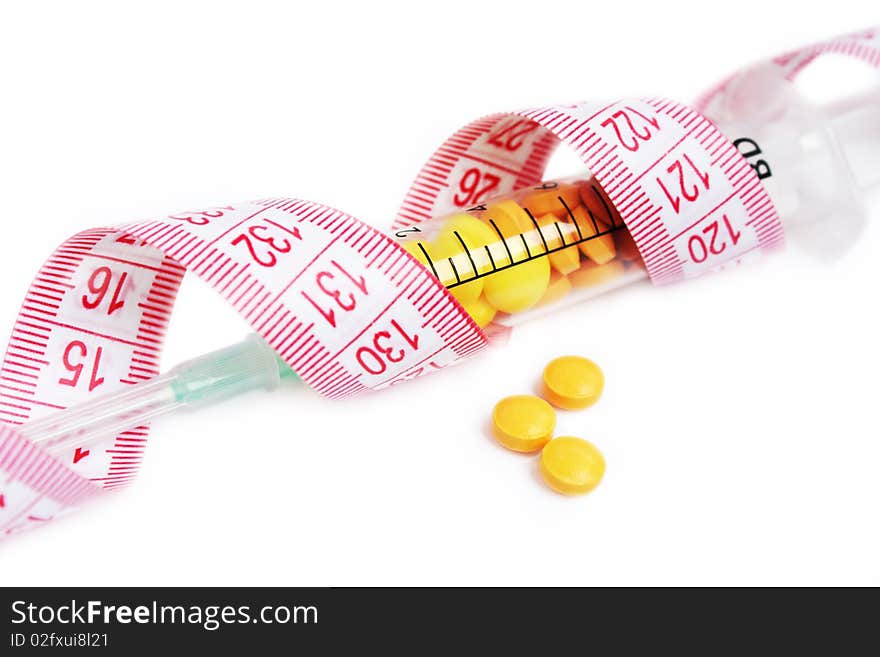 Syringe full with pills wrapped in tape measure illustrating wrong dieting and drug abuse